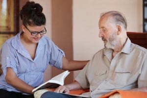 Carer reading to senior