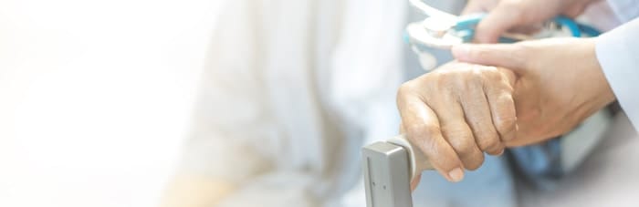 Elderly female hand holding hand of young caregiver at nursing home.Geriatric doctor or geriatrician concept. Doctor physician hand on happy elderly senior patient to comfort in hospital examination