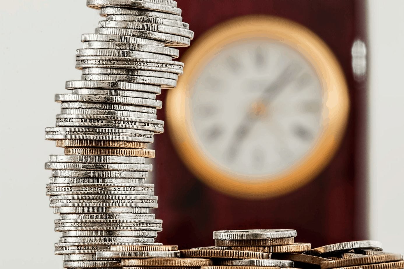 a stack of coins and a clock in the background