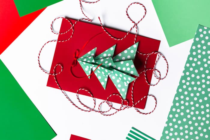 Handmade New Year postcard with paper christmas fir tree. Holiday idea for family time and gift for beloved. Fine motor skills, creativity development and fun. Flat lay top view