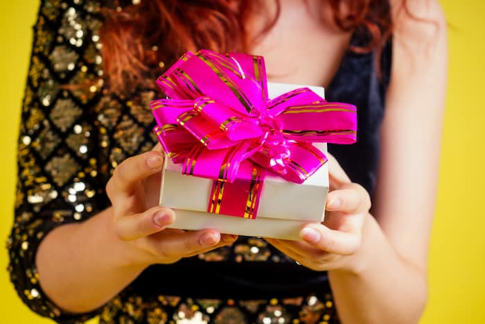 gift with a bow in women's hands.