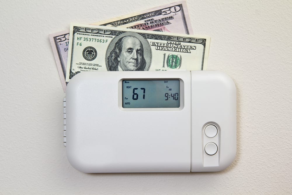 In door heating thermostat set at a room temperature and money