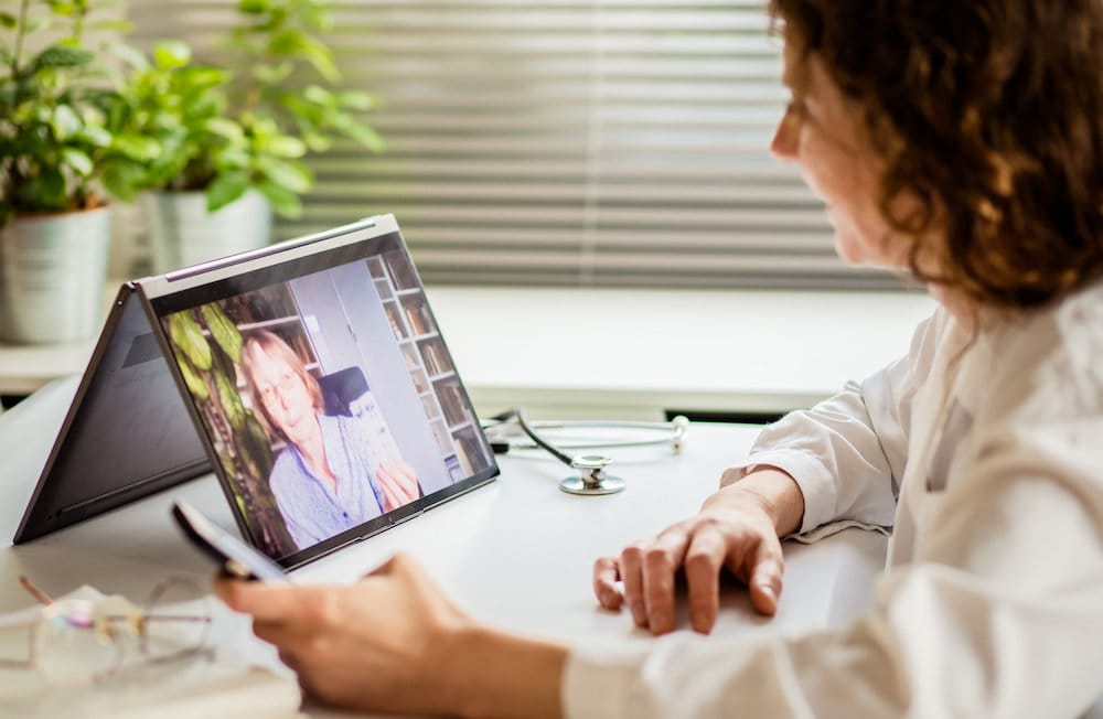 telemedicine concept elderly woman using laptop and taking her blood pressure