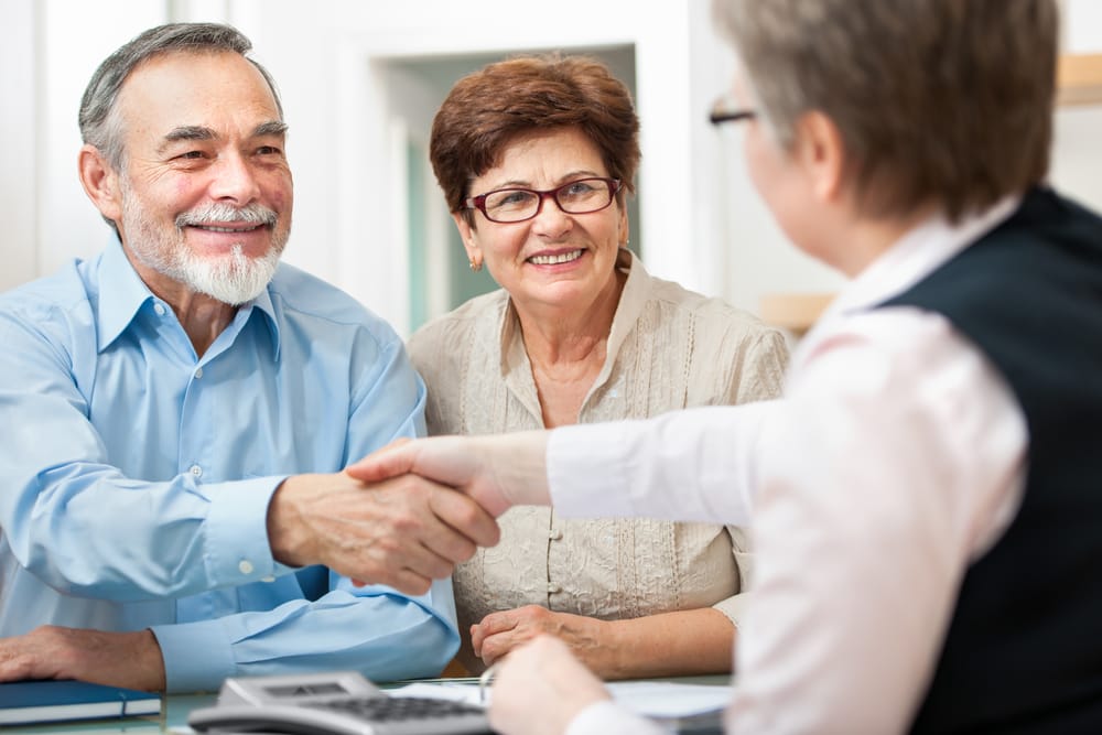 retirement planner chatting with two seniors