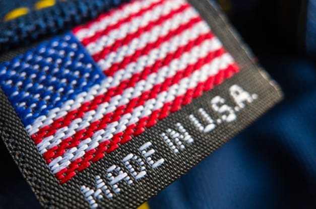 An extreme close-up of an apparel item's tag with an American flag and the words "Made in U.S.A." stitched into it.